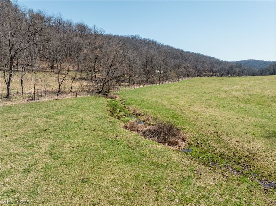 Live Auction 5/02/2026 10:00 AM - Parcel 5: 50.21 acres w/ 452’ frontage -This exceptional 188-acre offering of Holmes County land presents a rare to the market opportunity to own real estate in the well-known Stillwell area. Located just seconds from a paved road, the land features an older 3BR 2BA home, a 35' x 56' pole building, private septic, and a spring-fed water supply. The setting of the home offers peace and quiet, privacy, and ample land for gardening or animals. For the hunters, this property is situated in one of the county’s most sought-after hunting areas. Stillwell is well known for its hunting, and this property is no exception. Lots of deer trails, rubs, and scrapes, and each parcel is accessed from the east, providing favorable prevailing wind access and multiple ideal locations for food plots. A well-established trail system runs throughout the property, providing easy access. There is a nice ridgetop that spans most of the property, while the remainder of the land has a nice roll to it with a strong running creek, tons of road frontage, fenced pasture areas and ample building sites throughout. Most of the harvestable timber has already been marked and sold; these trees will be removed following the sale and are not included in the transfer. This selective harvest is expected to enhance the wildlife habitat and improve access with additional trails, bedding/cover, and browse. Whether you’re searching for a peaceful building site, prime hunting land, pasture ground, or just an investment, this property offers endless potential.