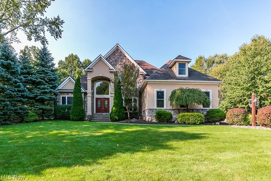 Welcome to Luxury living on a cul-de-sac street in the highly sought after Canyon Ridge Development of Perry. This custom built two story contemporary home is stunning! Enter the double doors to a two story foyer with Brazilian cherry hardwood floors and spend quality time in the huge great room gazing upon a wall of windows and ceiling to floor stone fireplace.  This home was designed with a grand first floor owners suite with crown molding and a luxurious spa bath with frameless shower, double sink vanity, ceramic floors, granite counter-tops and plenty of storage. The grand closet is certainly large enough for two! The first floor layout is open and ideally suited for entertaining and includes a formal diningroom. The eat-in kitchen offers a granite breakfast bar, stainless steel appliances, and custom cabinetry. Unique to this home is the additional 1st floor bedroom currently used as an office with an attached private full bath. Take the open lit staircase to the other bedrooms an
