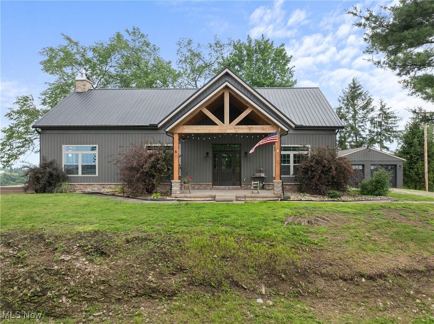 Welcome to 56380 Hospital Road—where timeless design meets modern craftsmanship on 1.46 scenic acres in Bellaire, Ohio. Perfectly positioned, this location offers quick access to I-470, making St. Clairsville and Wheeling a short drive away. Since 2015, this 3-bedroom, 2.5-bath home has been completely transformed inside and out. Every detail has been curated with quality, function, and comfort in mind. The main level features a private primary suite with a spacious walk-in closet and spa-like bath with a tiled walk-in shower and clawfoot soaking tub. The laundry room offers ample space, and a stylish half bath adds convenience for guests. The kitchen is a standout—equipped with custom cabinetry, a farmhouse sink overlooking the backyard, double wall ovens, an island with breakfast bar, concrete countertops combining durability and rustic charm, and a walk-in pantry. Flowing seamlessly from the kitchen is the show-stopping great room, where the 22-foot cathedral ceiling and a floor-to-ceiling stone gas fireplace create a striking focal point. Eastern Tennessee pine hardwood floors and expansive windows bring in sweeping views of the rolling valley. A bright 22x12 sunroom extends the living space, perfect for relaxing year-round with its own ductless heating and cooling system. Upstairs, the two bedrooms share a beautifully updated full bath with double vanity and tiled shower. Outdoors, enjoy two composite decks for unwinding as you overlook the property—ideal for pets, play, or your hobby farm dreams. The exterior has been fully updated with board and batten vinyl siding, a steel roof, stone masonry accents, gutters, soffits, and a welcoming covered porch framed by rustic wooden beams. A detached two-car garage includes electric and ductwork, ready for heat installation. A third garage bay on the lower level offers space for storage, a workshop, gym, or additional recreation. This home has been meticulously maintained and blends luxury, comfort, and practicality.