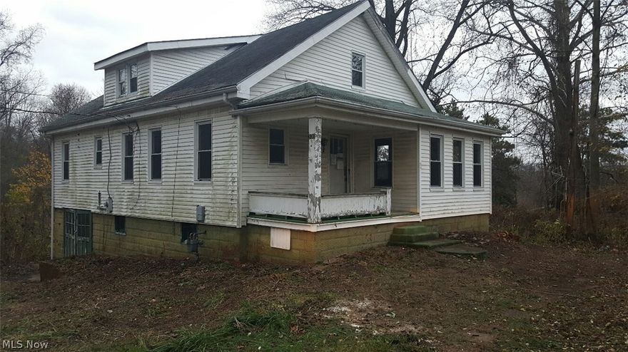 Home features front covered porch and attached 1 car garage in basement.