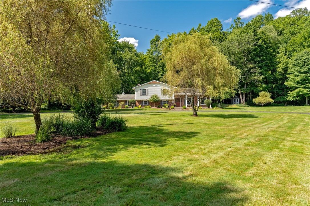 Don’t Miss This One-of-a-Kind Mid-Century Gem in Lake Lucerne—a perfect blend of timeless charm & modern elegance, nestled on 1.7 breathtaking wooded acres alongs a peaceful creek in the coveted Lake Lucerne Assn. Just min. from Chagrin Falls & award-winning Kenston Schools. This beautifully updated & meticulously maintained retreat is truly a rare find.
From the moment you enter the warm, welcoming foyer, you’ll feel the comfort & care that went into every detail. The sunlit living room—one of four inviting gathering spaces—features new carpet & a cozy gas fireplace w/ wood & tile accents, perfect for quiet times.
The dining room, w/ charming bay window & refinished hardwood floors, flows seamlessly into thoughtfully updated kitchen. Granite countertops, stylish tile backsplash, & restored original cabinetry—some w/ elegant glass fronts—adds add'l character. Stainless steel appliances, butcher block island w/open shelving, & brick-based breakfast bar blend form & function.
Step down into a cozy living area w/ a brick, wood-burning fireplace, built-in bookshelves, & large windows, framing the serene woodland views. The showstopper: a three-season sanctuary w/ floor-to-ceiling windows & rustic wood accents, blending seamlessly w/ the beauty of outdoors. Whether sipping morning coffee or winding down your day, it’s a space you’ll soon treasure.
Outside, the magic continues: mature trees, curated landscaping, surrounding a cascading stone waterfall, built-in gas fire pit on paver patio, beneath a pergola. All set to the gentle murmur of the creek—your private, park-like oasis.
First-floor full bath & spacious laundry lead to bonus room w/wall of closets, boot bench, & flexible room for movie viewing, game night, crafts/whatever your need.
Upstairs four bedrooms, incl. a private primary suite w/ tiled bath & more stunning views.
This home offers rare character, cozy sophistication, & a deep sense of calm. It's not just a place to live—it's a place to love.