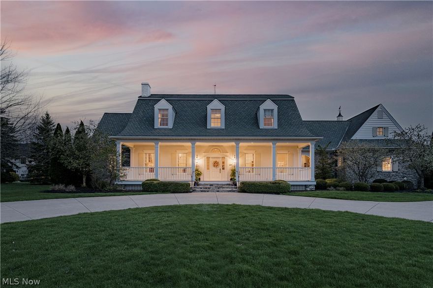 Elegance and architectural distinction define this well-known exceptional Cape Cod home. The home reflects Southern influences and traditional New England architecture, while featuring high-end finishes throughout. A circular driveway and an expansive front porch create a grand approach. Inside, the foyer showcases Iconic columns with arched openings and detailed millwork, custom brass light fixtures, and rich hardwood flooring that flows throughout the main level. Just off the foyer, the living room features detailed wainscoting and a refined fireplace with a stone surround. The formal dining room offers elegant wood details and enough space to host the largest of gatherings. The vaulted great room is the showpiece, perfectly centered at the heart of the home. It features exposed wood trusses, a circular oculus window, custom built-ins, and a dramatic dark stone fireplace. The well-designed chef's kitchen features custom wood cabinetry, granite counters, and a Wolf 6 burner gas range. A laundry room, mudroom, and half bath are located nearby. An additional half bath sits near the great room and primary suite. The first-floor primary suite provides a private retreat. It includes a spacious bedroom, a marble-appointed bath with custom vanities, and a large walk-in closet. Upstairs, three bedrooms each feature an ensuite full bath. A large bonus or recreation room offers flexible living space conveniently located on the second floor instead of the lower level. It connects to two additional rooms that would make the perfect home gym and office. The private back stone patio offers a private and peaceful outdoor setting. An unparalleled opportunity in sought after Fox Meadows!