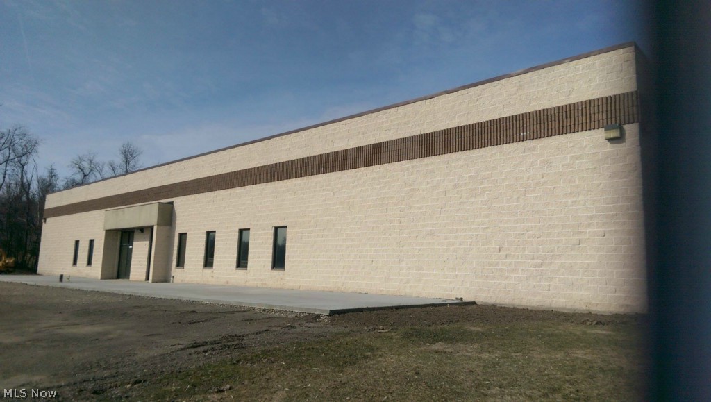 The building totals 9,000 SF (60'x150') with walls that are constructed with 12" insulated block, 6" reinforced concrete floor and two bridge cranes (5 ton and 2 ton). The building is equipped with 480V-3Ph electrical service with 600 Amps. Two overhead doors, each measuring 14'x14'' East entry is a pit dock while the west end is drive-in @ ground level. There are air lines around the perimeter of the building requiring an air compressor. Natural gas heating tubes with 3 additional infrared heaters. The roof is a metal deck with 3" insulation and a rubber covering. Metal halide lighting. 2 Public restrooms in the main area, as well as a tool cage with motion sensor lighting. This building also offers a finished office space with a private full bath.