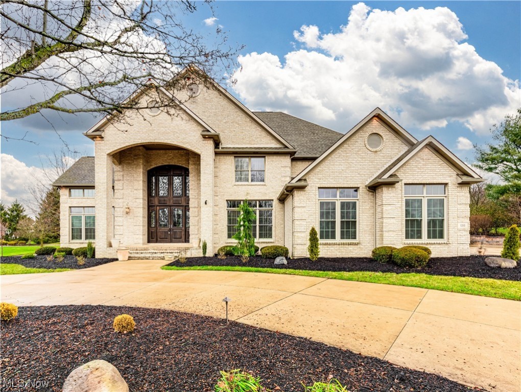 Stunning all brick home on a corner lot. This expansive floorplan is excellent for entertaining and everyday living! With 5 bedrooms, 6.5 baths, a partially finished basement, a 3-car garage, an in-law suite, & 7,667 sq feet of bright & airy living space. A grand foyer leads to a formal dining room (right) with high ceilings & a charming sitting room (left). The family room features a floor-to-ceiling stone-surrounded gas fireplace, and 2 story windows. Spacious eat-in kitchen with an oversized granite island, stainless appliances, a walk-in pantry, and under-cabinet lighting. The open great room with a gas fireplace, built-in storage, TV with security camera display, shelving, a full bar, and sliding doors to the patio. The office has access to the covered porch and a full private bath. Completing the 1st floor is a laundry room, 1/2 bath, & an In-law suite with kitchenette, sitting room, bedroom, & full bath. Upstairs you'll find 4 generous bedrooms with walk-in closets and 3 full baths including the master suite. Double doors lead into the vast master suite with a wardrobe, a master bath with a jetted tub, 2 vanities, a tile walk-in shower with glass blocks, and a walk-in closet (15x8). The partially finished basement has a large rec room, full bath, a roughed bar or kitchenette, and ample storage space. The three car garage has ample storage and is heated. The tranquil fenced in backyard includes a gas fireplace, pergola, covered porch, a brick patio, and a water feature with stunning landscaping. This allotment is great for walking, close to schools, shopping, highway access, and Gervasi Vineyard. This home is a must-see! Book a showing today!