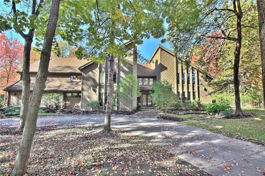 Set on 1.23 acres of lush gardens and waterfalls, this remarkable Pepper Pike residence offers both privacy and natural beauty. Inside, dramatic high ceilings and expansive picture windows fill the home with natural light and showcase the spectacular backyard and private, tree-lined driveway. The main level includes a formal dining room, living room, a spacious great room overlooking the picturesque grounds with access to a large deck, plus a huge kitchen, a comfortable family room, and much more. The second-floor primary suite features a cozy fireplace and a private balcony with serene views of the grounds, while the luxurious primary bath includes a large walk-in shower. The finished walk-out lower level offers exceptional living and entertaining space, including a guest suite, a full kitchen, a large recreation room, and more. With 5 bedrooms, 5 full and 2 half baths, and a 4-car heated garage, this home combines light-filled spaces, luxury, and comfort in a truly exceptional setting.