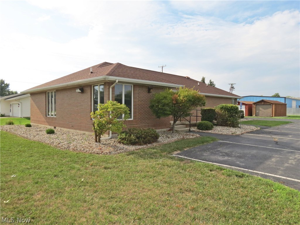 Very versatile brick medical office building. 2084 sq ft on just under 1 acre. Foyer entry with coat rack. Very spacious waiting room measures 13x28. Reception/file area measures 11.5x17. Expansive layout with versatility for large practice, multiple physicians or other types of office use. 8 total exam rooms or offices. One far back office has it's own full bath. Half bath off of the hallway and half bath in the lab room. New roof approx. 8 years ago. New hot water tank 3 years ago. Ample parking with 21 spaces. 2 storage buildings. Building currently sits on 1.9 acres and price is based on 1 acre corner lot being split and sold separately.