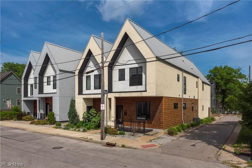 Tax Abatement from 2018 through 2032. STUNNING corner-unit Colonial-style Townhome in Tremont, just steps away from the Towpath Trail and a short walk to charming local restaurants, shops, and close proximity to highway access. This 3 bed, 3 full bath is complete with a private deck off the master suite. NO Maintenance or HOA Fee. Enjoy an ultra-contemporary open concept within the main living area with soaring ceilings, a custom-built floating staircase, engineered hardwood floors, high-quality finishes, abundant natural light, and a full bathroom for your guests. The kitchen has stunning custom quartz counters, a large waterfall island, custom cabinetry, stainless steel appliances, and a separate bar niche area with a beverage fridge. The garage on the rear makes it easy to bring groceries into the kitchen. The master bedroom features a floor-to-ceiling wood accent wall, vaulted ceilings, a private deck, an oversized walk-in closet with custom shelving, and a spa-like en-suite bath w