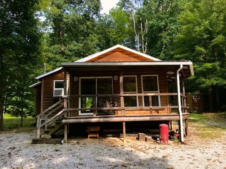 Nature lover's dream!! Beautiful well-built cabin in private wooded setting with stocked pond. Perfect getaway location or finish the plumbing and add septic and move in. Enjoy the views from either the front and back porch and the dock overlooking the stocked pond. Completely remodeled inside with natural wood planks and trim, custom built storage, new roof in 2018, all new electrical. The cabin is ready for a full bathroom and laundry. There is a wood stove and heating/cooling unit that can be placed in the window or mounted on the wall. Conveniently located a mile outside of Newcomerstown in a peaceful, wooded setting. Must see to appreciate the details and location.