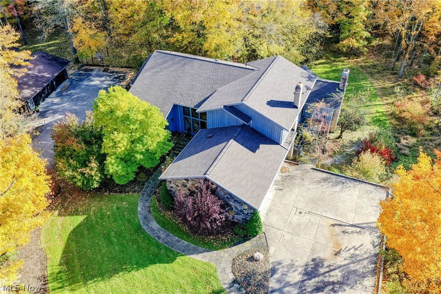 Form and function coalesce in this stunning contemporary retreat in Pepper Pike. With over 6,000 square feet of living space, this home has been completely redesigned for ease of use and sophisticated modern life. Situated on a serenely wooded 1+ acre lot, this home is set back from the street and surrounded by landscaping. As you step inside, you’ll immediately appreciate the open, cohesive atmosphere of the main living areas. Step up to the dining room, where sliding doors open to the back deck, or step down to the living room, which features a stone accent wall and striking windows. The kitchen features gorgeous quartzite counters, contrasting cabinetry, and a breakfast bar that overlooks the hearth room, where a stunning bay window frames the backyard. The first floor owner’s suite includes an en-suite bath with an extended vanity area and an oversized step-in shower. A floating spiral staircase leads upstairs, where you will find 4 bedrooms and 3 full bathrooms, including the seco
