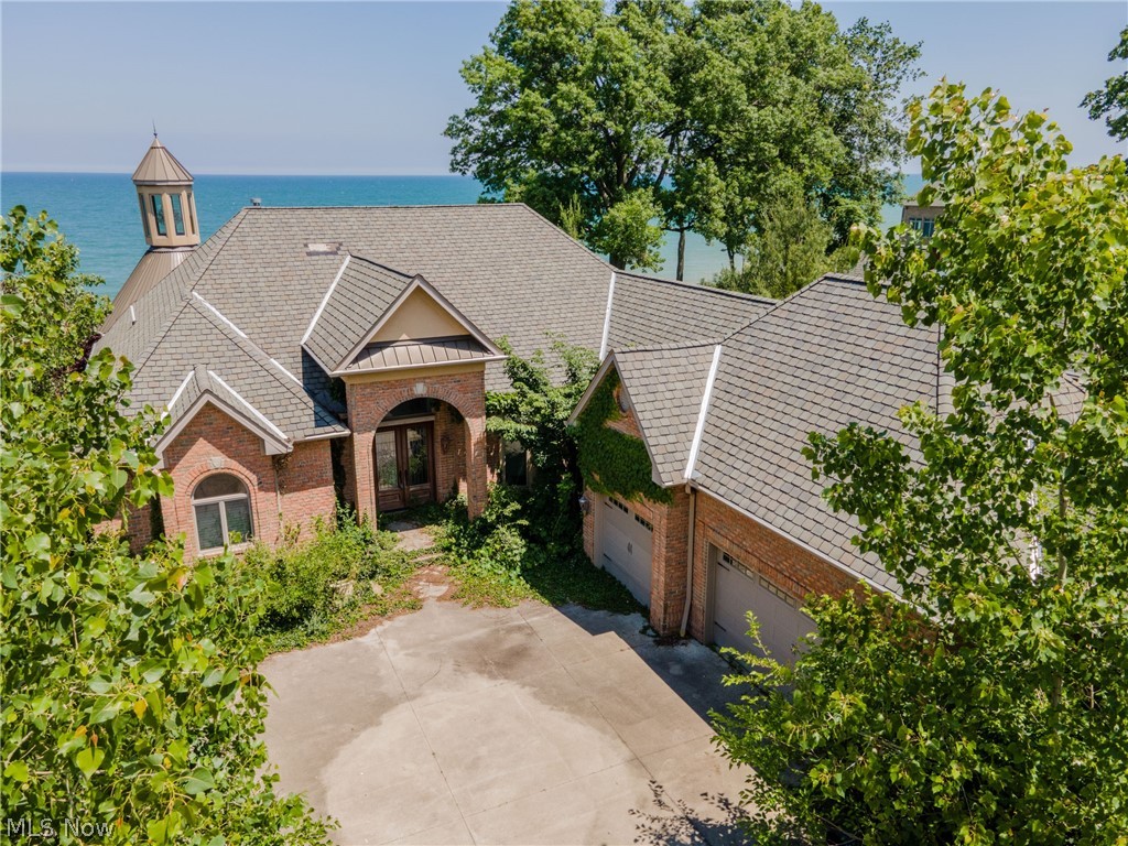 This is truly a special opportunity! This custom home has so much to offer that is simply unparalleled. The lot is one of only a handful that is a non-erosion lot with a beach and direct water access, there is even a small boat house on the beach for all of your toys and gear. Up the steps from the beach is a fantastic custom built home offering over 7,000 sqft of space, that is all flooded with natural light. The first floor offers tons of living space with a large great room in the middle and a fantastic den behind the kitchen with walls of glass looking North and West to capture every evening's sunset. The master on the first floor also has beautiful lake views and an enormous master suite. Downstairs there is a second full kitchen and living area, bedrooms with attached bathrooms, an office and a theater room. Bring your finishing touches inside and out and bring this property back to it's full glory and one of the shining stars of our North Coast.