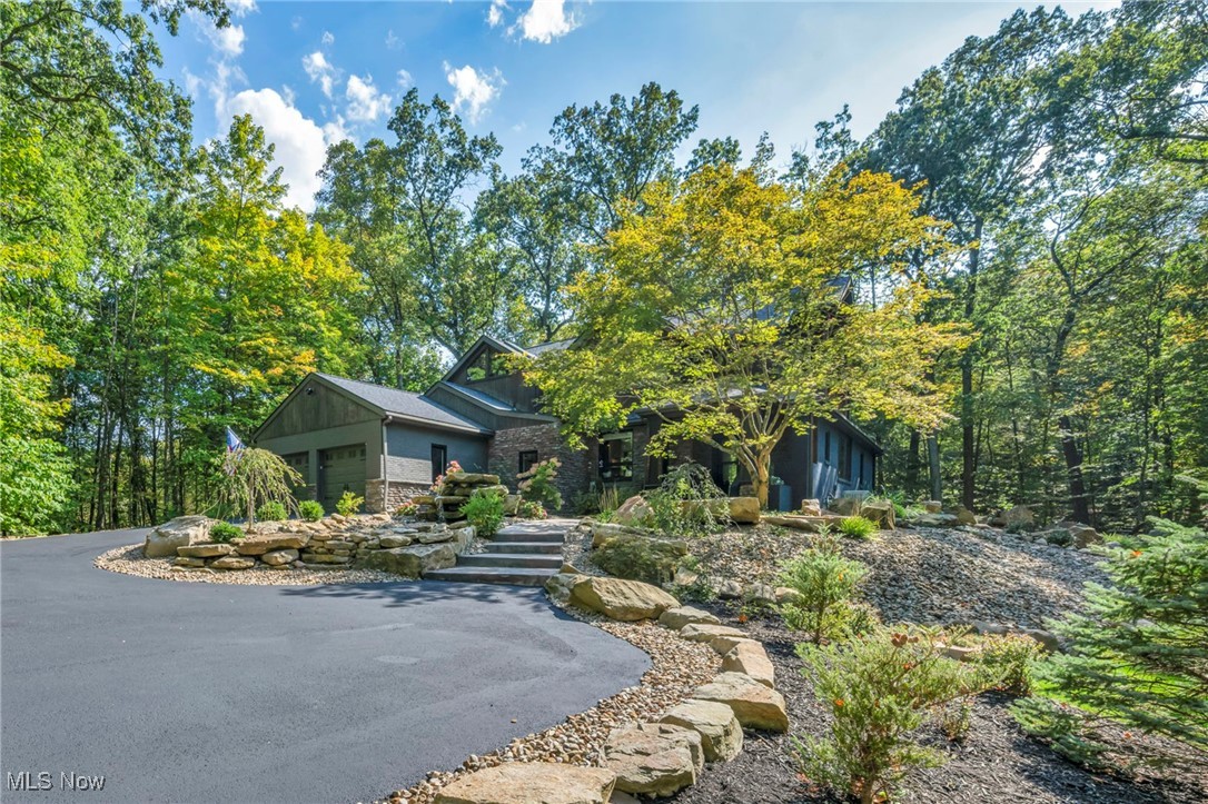 Colorado-inspired living in Bath Twp! Nestled on a private 2.52-acre wooded cul-de-sac lot in the highly rated Revere School District, this extraordinary, fully renovated property w/well over $450,000 in recent updates blends rustic charm w/ modern luxury, creating a one-of-a-kind retreat. Surrounded by serene woods, the home brings the outdoors in w/ floor-to-ceiling windows, skylights & wraparound decks that make every day feel like a refined escape in the treetops. Every detail, both inside & out, has been carefully curated, from vaulted wood-planked ceilings, knotty alder doors & woodwork & live-edge finishes, to custom tilework, distinctive fixtures & thoughtfully designed landscaping & hardscaping, making the property as much a work of art as it is a home. A striking stone waterfall outside the front entry welcomes you to over 5,000 sq ft of light-filled living space perfect for gathering & entertaining. A dramatic 2-story great room features a soaring stone fireplace & wall of glass overlooking the trees. A gourmet kitchen showcases granite countertops, 2-tone cabinetry, stainless appliances, artisan backsplashes & abundant storage, flowing seamlessly to a dining area w/ picture window & sunroom w/ skylights & deck access for effortless entertaining. The entire 2nd floor is devoted to a luxurious primary suite w/ vaulted ceilings, multiple sitting areas, 2 walk-in closets, fireplace, private deck, spa-inspired bath w/ double vanity & custom-tiled shower & laundry room. The finished walkout lower level offers a family room, stone fireplace, 2 bedrooms w/ egress windows, full bath, 2nd laundry & storage room, plus walkout access to outdoor gathering spaces, including a stamped concrete patio w/ firepit. A detailed list of updates is available upon request.
INCLUDED are ALL kitchen appliances, washers/dryers & all window treatments. Conveniently located near I-77, I-271, schools & plenty of shopping, restaurants, parks, trails & many other local attractions.