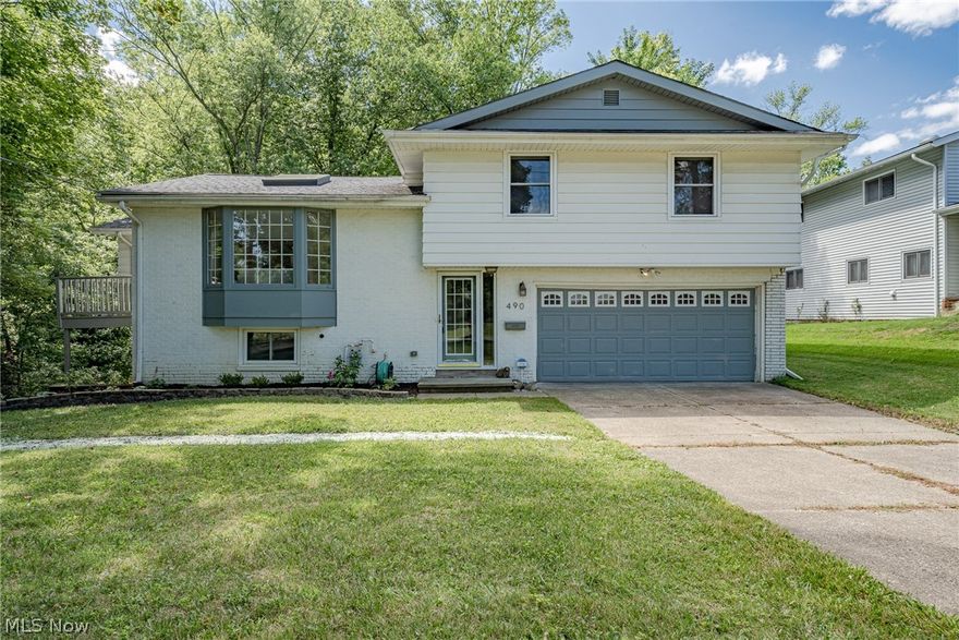 Wow! Move right into this stunning split-level home home in Bedford! Situated on a wooded lot overlooking a creek, this well-kept home features over 3500 square feet with 3 bedrooms, 3 renovated bathrooms, spacious open-plan living areas, crisp neutral paint, and tasteful updates throughout. The front door opens into a welcoming foyer that ascends to the living room. Here you will find two picture windows, a skylight, and gleaming hardwood floors that flow throughout the main and upper levels. The living room is open to both the formal dining room and the eat-in kitchen. The kitchen boasts stainless steel appliances, granite countertops, and an island with a breakfast bar! A walkway connects the kitchen to a back balcony and provides views of the family room below. The family room features a soaring vaulted ceiling, sliding doors to the back porch, and large windows that fill the space with light. The lower level also includes a bedroom, a bonus / dining area, a laundry room, and an en