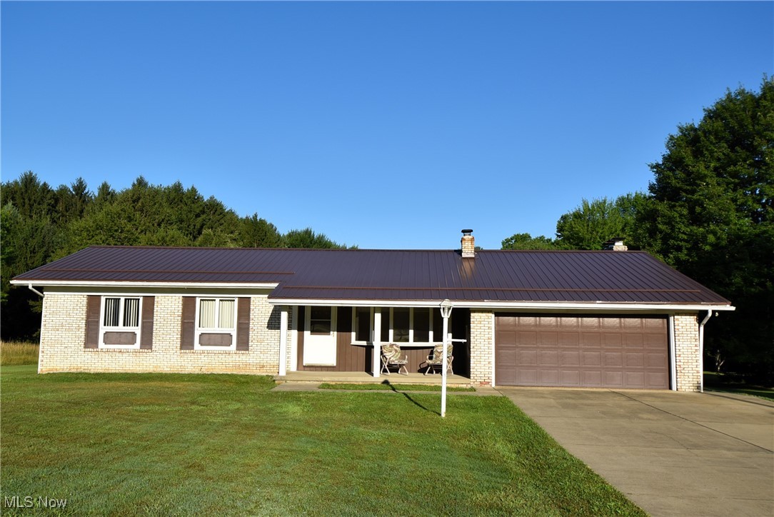 Welcome to this spacious ranch home nestled on 1.6 acres, offering comfort, functionality, and plenty of room to spread out. Step inside to find a bright living room with a charming bay window and a cozy family room featuring a stone gas fireplace that leads to the 3 season sun room and back covered patio. Eat in kitchen area with plenty of storage and a pantry closet. The primary bedroom boasts a walk-in shower and private access to an enclosed hot tub area—perfect for unwinding in peace. Two other bedrooms to make first floor living easy. Downstairs, the full basement is designed for entertaining with tile flooring and a built-in bar. The attached 2-car garage features nature stone flooring, laundry hook-ups, water, and electric. Car enthusiasts and hobbyists will love the impressive detached garage with four oversized bays with —ideal for vehicles, equipment, or even a separate workshop or entertainment space. The first bay includes both front and rear access doors for added convenience, and a separate drive on the left side of the home provides easy access to the garage. Both the home and the detached garage are topped with a new metal roof installed in 2024, ensuring durability for years to come.