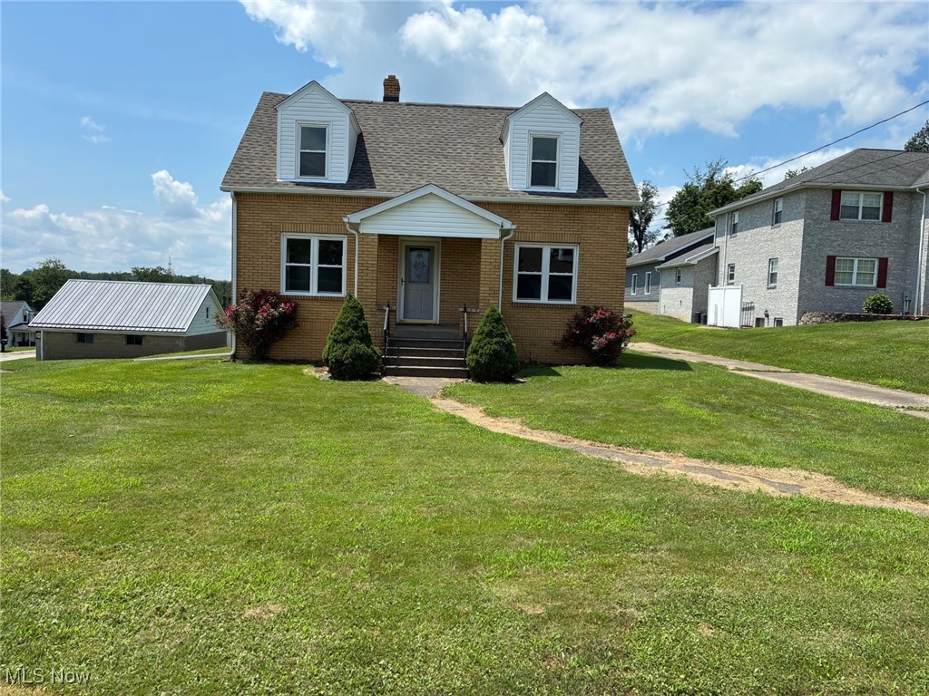 Weirton Heights – Looking for acreage in the city? This level half-acre lot could be yours, along with a charming 3-bedroom brick Cape Cod that offers numerous recent updates! Improvements include blown-in insulation, fresh paint throughout, a newly added full bath on the main floor, new flooring throughout, a new roof (2024), updated furnace and AC (2015), new dormer siding (2024), replacement windows (2015), and updated plumbing (all per seller, approximate dates). The upper level offers two generously sized bedrooms with abundant closet space, a full bath, and a convenient built-in cabinet with drawers in the hallway. Step outside to enjoy the expansive, level half-acre lot — ideal for a future pool, gazebo, garden, or simply enjoying the spacious yard. Relax on the covered front porch in the evenings. Conveniently located near Route 22 for easy access to Pittsburgh, and close to the hospital, schools, shopping, post office, churches, and all the amenities this centrally located neighborhood has to offer.