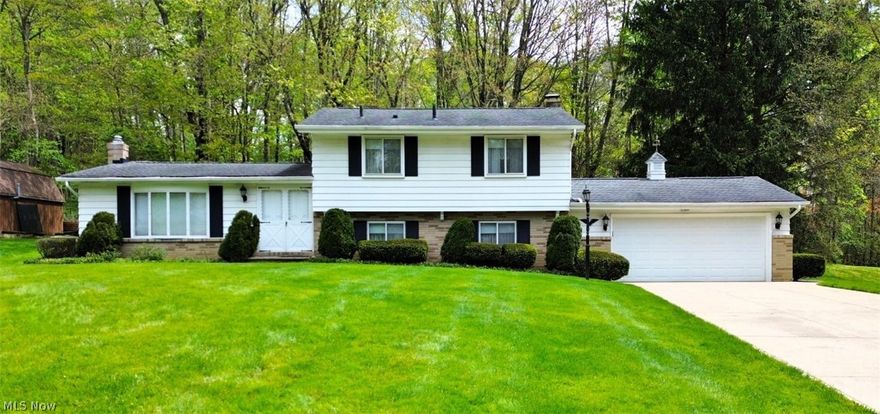 You'll love this big inviting and meticulously maintained split-level home nestled on a gorgeous, tree-lined street in a highly desirable neighborhood, just minutes from Cuyahoga Valley Nation Park! With timeless curb appeal, this home features a classic white aluminum and beige brick exterior, a two-car attached garage, and a beautifully landscaped yard complete with a charming front light post, walkway, and inviting entry. Enter through the double front doors into a spacious foyer with tile flooring, coat closet, and elegant wood staircase. The main living areas offer an open, flowing layout with hardwood floors, beautiful high ceilings with beams, and large bay windows with unique octagonal bump-outs that fill the home with natural light. The kitchen, boasts ample cabinetry, a fantastic layout, and an open ceiling concept that connects seamlessly to the dining area. Upstairs, you'll find three generously sized bedrooms, all with hardwood floors and ample closet space. Plus, a full bath in great condition and a large linen closet. A pull-down attic provides additional storage. Lower level offers a cozy den with built-ins, wood paneling, and a gas fireplace (not recently used; buyer to verify). A spacious laundry/utility room doubles as a mudroom and includes a washer/dryer, laundry sink, and abundant storage. The basement utility area showcases extensive custom cabinetry crafted by the seller, a skilled woodworker. Mechanical updates include a furnace (2011) and hot water tank (2013). Please enjoy our attached video tour and book your price showing today?
