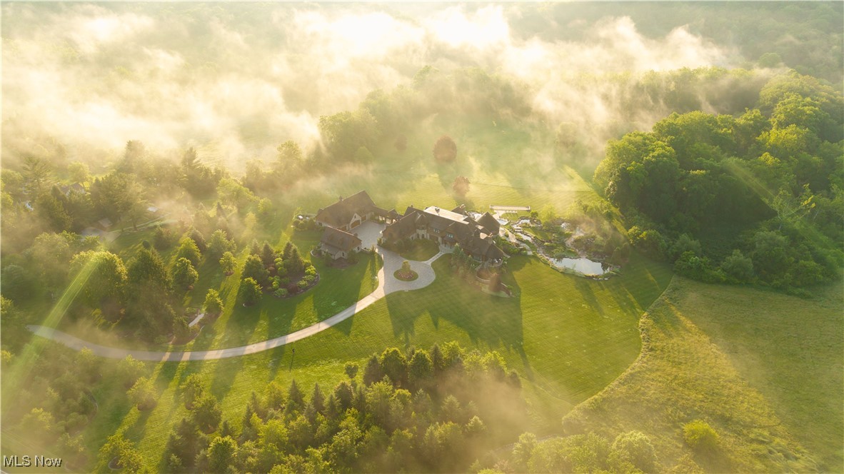 Welcome to the most iconic property in the Midwest. Completed in 2018, 2875 Chagrin River road spans 61 acres along the Chagrin River in Hunting Valley, OH. This shingle style estate, crafted by architect Charles Fazio and World Renowned yacht interior designer Ari Loar, redefines luxury. Every element, from the bespoke Italian furnishings and lighting to the sophisticated fusion of glass, metals, and woods, crafts a unique story in each room. Upon entry, you are greeted with a Bentley Home chandelier and exquisite Italian marble flooring. To the left of the foyer, the dining room features a stunning “Peacock mosaic mural” by SICIS, leading to a living area with impressive ceiling woodwork and a chef’s kitchen with quartzite and marble countertops, and a custom La Cornue Chateau professional series range. The first level also includes a mudroom, laundry, and butler's pantry with a third dishwasher, home office and primary suite. The primary suite opens with an awe-inspiring atrium with a custom painted window ceiling and features dual baths, a fireplace, and a private patio with an additional fireplace. Descend the curved staircase or opt for the elevator to reach the lower level. Here you’ll find a state-of-the-art gym, additional primary bathroom and closet, sauna, steam room, and grand entertainment area complete with a bar, billiards table, stage, and a temperature-controlled wine room adorned with another exquisite SICIS mural. The second level offers five bedrooms with ensuite bathrooms, including a nursery, and a screening room. The outdoor area includes a four-season room, plunge pool, bocce ball court, and greenhouse. An arched breezeway leads to a detached garage with space for up to 20 cars and a bar, golf simulator, and barber room above. Plus, a heated driveway. This estate is a masterpiece of design, blending unique amenities, high-quality finishes, and impeccable craftsmanship—a distinguished setting for both living and entertaining.