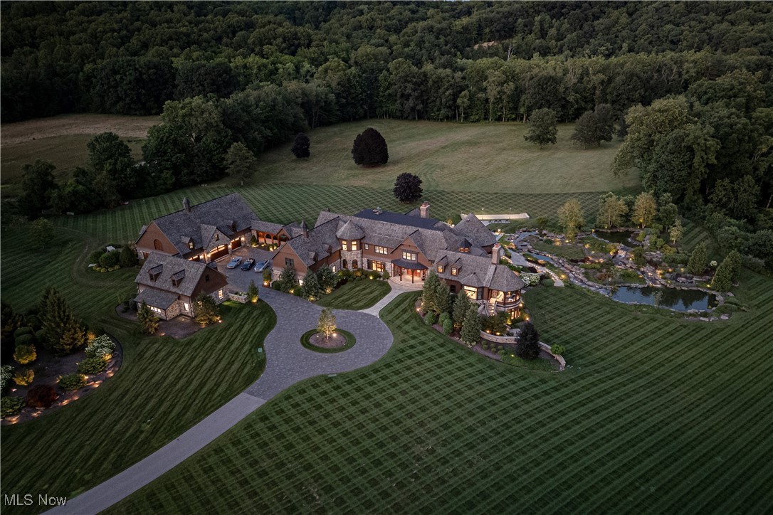 Welcome to the most iconic property in the Midwest. Completed in 2018, 2875 Chagrin River road spans 61 acres along the Chagrin River in Hunting Valley, OH. This shingle style estate, crafted by architect Charles Fazio and World Renowned yacht interior designer Ari Loar, redefines luxury. Every element, from the bespoke Italian furnishings and lighting to the sophisticated fusion of glass, metals, and woods, crafts a unique story in each room. Upon entry, you are greeted with a Bentley Home chandelier and exquisite Italian marble flooring. To the left of the foyer, the dining room features a stunning “Peacock mosaic mural” by SICIS, leading to a living area with impressive ceiling woodwork and a chef’s kitchen with quartzite and marble countertops, and a custom La Cornue Chateau professional series range. The first level also includes a mudroom, laundry, and butler's pantry with a third dishwasher, home office and primary suite. The primary suite opens with an awe-inspiring atrium with a custom painted window ceiling and features dual baths, a fireplace, and a private patio with an additional fireplace. Descend the curved staircase or opt for the elevator to reach the lower level. Here you’ll find a state-of-the-art gym, additional primary bathroom and closet, sauna, steam room, and grand entertainment area complete with a bar, billiards table, stage, and a temperature-controlled wine room adorned with another exquisite SICIS mural. The second level offers five bedrooms with ensuite bathrooms, including a nursery, and a screening room. The outdoor area includes a four-season room, plunge pool, bocce ball court, and greenhouse. An arched breezeway leads to a detached garage with space for up to 20 cars and a bar, golf simulator, and barber room above. Plus, a heated driveway. This estate is a masterpiece of design, blending unique amenities, high-quality finishes, and impeccable craftsmanship—a distinguished setting for both living and entertaining.