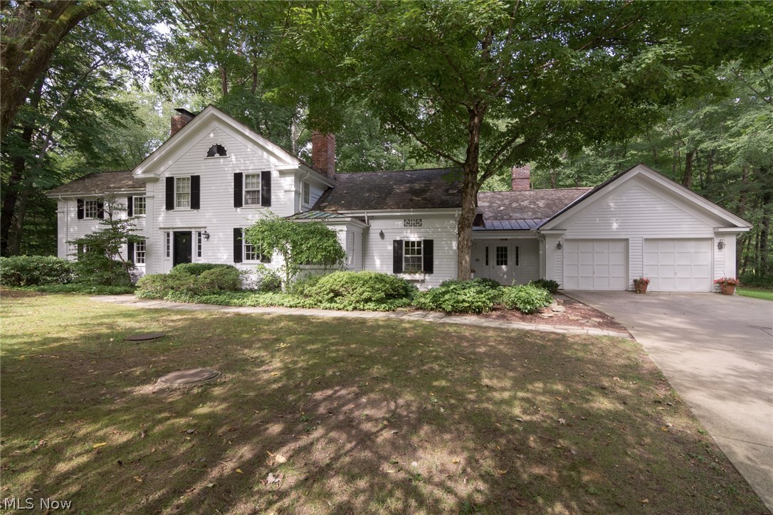Tucked away on 2.8 acres in the heart of the Chagrin Valley, this meticulously maintained New England colonial is ready for a new owner to enjoy. Originally built by legendary Cleveland architect, Munroe Copper, this home features a delightful blend of contemporary amenities with historic charm. Refinished wide plank hardwood floors greet you in the foyer and flow into the spacious living room. Enjoy cozy evenings at home in front of the fireplace, or sip your morning coffee on the covered balcony that overlooks the serene backyard. A step down sunroom provides more views of the sylvan surroundings. The dining room connects to the kitchen and the charming step down family room. The kitchen features quartz counters, white cabinetry, stainless appliances, and tin detailing, plus a breakfast nook with a wall of windows. A powder room and a study with built-ins and a window seat complete the first floor. Upstairs, you will find four spacious bedrooms and three full bathrooms, including the