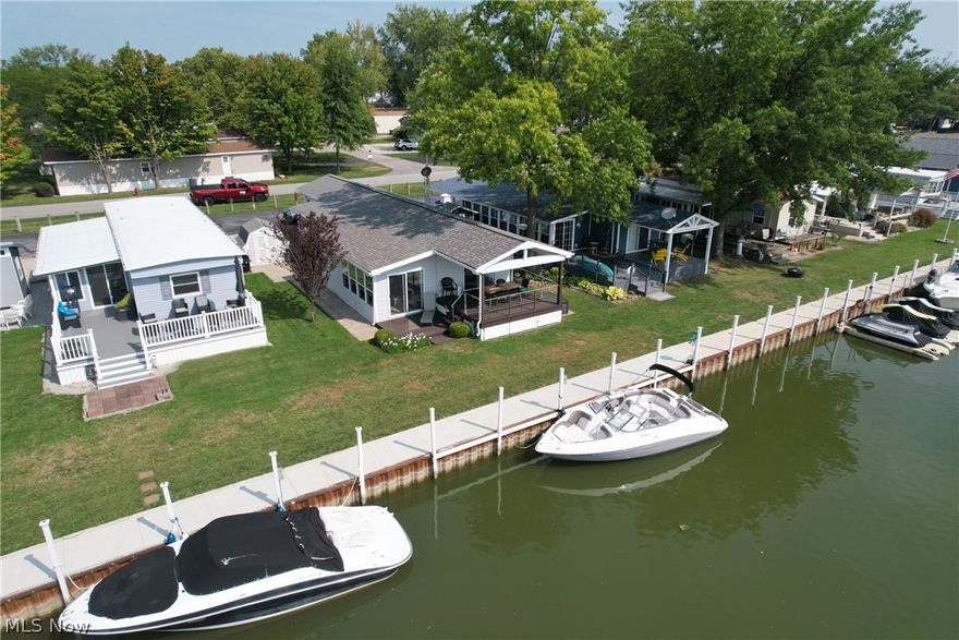 If you have been waiting for a turn key vacation home with dockage in the heart of vacationland, your search is over! Now for sale is this beautiful year round home in sought after West Harbor Lagoons Boataminium directly adjacent to East Harbor State Park. 40' of seawall awaits your boat directly outside of your back door.Two new beautiful decks overlook the canal that leads into West Harbor and Lake Erie. This is not a leased lot, you own the land and the dock! Attention to detail is obvious upon arrival. On the exterior you will notice the newer landscaping, new rear decks, newer concrete dock, a storage shed, and a 2 yr old HVAC unit. On the interior is an open concept with 2 bedrooms, 1.5 bathrooms, laundry, open kitchen, and a ground level entry room. This floorplan is perfect for hosting your family and friends! Furniture, kayaks, and paddleboards can be negotiated into the sale which will allow you to start enjoying your new vacation home immediately. Welcome to lake life!