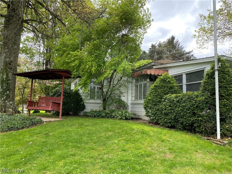 Beautiful 1 1/2 acre lot with a three bedroom 2 bath ranch home in East Palestine.  Enjoy your morning cup of coffee in the enclosed front porch over looking the large front yard or it would be a great place to relax at the end of the day.  Eat in kitchen with appliances.  Spacious living room has a fireplace with insert.  There are hardwood floors underneath the carpet.  Full basement with 1/2 bath, utility room with washer, dryer, kitchen sink and stove.  Family room with second fireplace, work shop and plenty of storage.  Over sized 2 car detached garage with additional sheds.  City water and septic system.  Septic has been inspected by the county.  Home is being sold as is.  Great Possibilities!