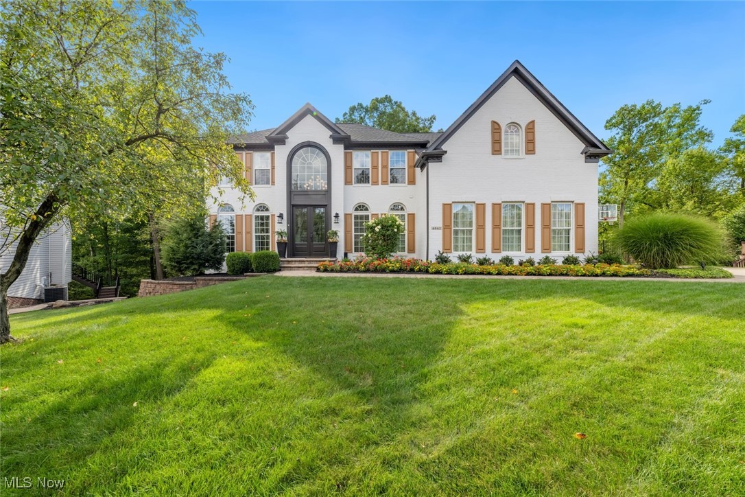 Beautifully appointed Sutton Woods colonial offering timeless design and modern updates. The 2-story foyer features hardwood floors, crown molding, and a grand staircase. Home office with built-in desk, updated living/dining rooms, and a kitchen with Kraftmaid cabinets, island microwave, porcelain tile, and morning room overlooking wooded lot. Family room boasts 6” white oak floors, stone gas fireplace, feature wall for 85” TV, and 2nd staircase. First-floor laundry doubles as butler’s pantry/coffee bar. Upstairs: 4 bedrooms with LVT flooring, updated baths, custom window treatments, and a primary suite with 3 walk-in closets and dressing room with California Closets. Finished walkout lower level includes fireplace, wet bar, billiards, lounge, exercise room, and full bath. Exterior highlights: patios, irrigation system, Heartland barn, new garage doors, epoxy-coated garage floor, and professional landscaping. Air conditioning 2019, new roof 2021, and new furnace 2023. Quiet cul-de-sac near I-77, Turnpike, Metroparks, and downtown Cleveland/Akron.