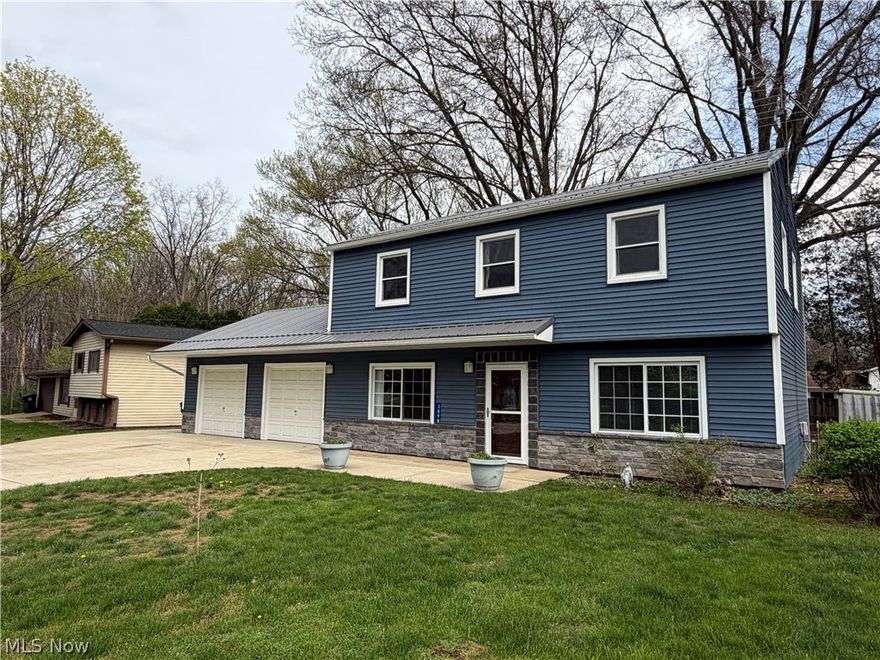 Don't miss the opportunity to see this meticulously maintained colonial in the heart of Brimfield. Updated from top to bottom with fresh paint throughout, this beautiful home is sure to impress. The main level features newer LVP flooring leading into a separate dining area and a completely updated kitchen, which includes newer white cabinets, appliances, a kitchen island with quartz countertops, and a convenient pass-through to the dining room. Down the hall, you will find main-floor laundry, a half bath, and an oversized living room featuring a fireplace and a wall-mounted TV that stays with the home. Upstairs offers four bedrooms, including a spacious primary suite with a fully renovated bathroom and walk-in shower. The main bath is absolutely stunning with a tile shower, quartz countertop sink and updated flooring. There is also a bonus office that could serve as a potential fifth bedroom. Outside, a large parking pad with extra side concrete provides ample space for multiple vehicles, a boat, or an RV. The property also includes two separate stall garages, and a private backyard complete with a pergola, shed, and fire pit. Key updates include; Metal roof and vinyl siding (2018), Concrete drive and back patio (2019), LVP flooring (2021), Carpet (2022) Pergola (2022) and so much more! Schedule your private showing today!