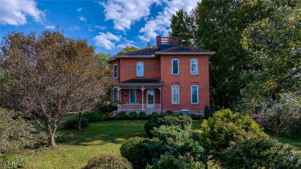 Step into timeless elegance with this beautifully preserved all-brick Italianate Colonial, built in 1881 and rich with Oberlin history. Immaculately cared for, this one-of-a-kind home blends historic charm with thoughtful modern updates throughout. Offering 4 to 5 spacious bedrooms, two full bathrooms, and TWO full kitchens, this home provides exceptional versatility. The main remodeled kitchen has been designed to honor its heritage, including custom hardwood cabinetry, a central island, quartz countertops, and all-new appliances. A newly renovated main-floor bathroom and laundry room, refinished hardwood floors in multiple rooms, and a replaced main plumbing stack and lines reflect the level of care and attention this home has received. The property is equipped for comfort and efficiency with two furnaces (installed in 2016 and 2019) and two central AC units (both new in 2019). Electrical updates add further peace of mind. Outside, you'll find a 2-car garage, two additional outbuildings—including a 32x48 steel building with electric and a car lift, perfect for a workshop, hobby space, or storage—and the original granary, thoughtfully converted into a functional workshop. The walk-out basement is clean, bright, and dry—a rare and valuable feature in a home of this age. The beautifully landscaped grounds include a picturesque pond and a gazebo, creating a serene and private retreat just minutes from the amenities of town. This is not just a home—it's a piece of Oberlin's history, lovingly preserved and ready for its next chapter.