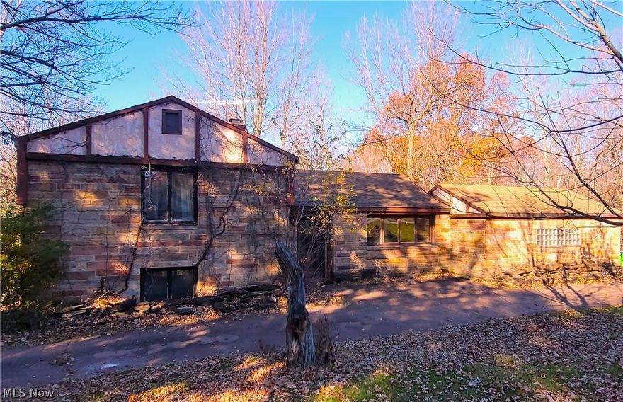 Welcome Home to 18383 Orchard Hill! This "Art-Deco" style home is on a large (1.58 acres) beautiful lot located in Walton Hills on a quiet street. A rare opportunity to become part of a community that seldom has homes for sale. Features include a circular stamped driveway and an attached garage. Roof is estimated to be 10 years old. A large workshop area is in the basement. This home originally had 3 bedrooms, however, the last owner removed a wall from the 3rd bedroom on the lower level to make a larger entertaining space. The wall can be rebuilt to make this a 3 bedroom home again. Lower level includes a fireplace and access to the backyard which has a custom built fireplace in the back and partial access to a creek. This home is priced to sell to allow the new owner to add their finishing touches and complete repairs. There is a "country-feel" in this established community but is very close to shopping, SR-8, I-271, I-480, I-80 (Ohio Turnpike).  Short drive to downtown Cleveland, do