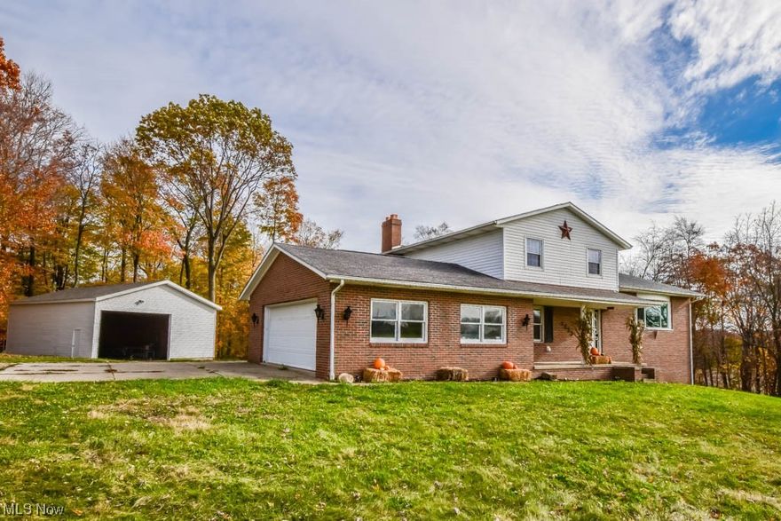 Enjoy peaceful country living in this nicely updated 4 level split situated on over 3 acres of farmable land! The unique layout offers ample living space plus the potential for an in-law suite in the walk-out lower level! A welcoming front porch invites you into the main landing that leads to a guest bath, two car garage, laundry room and cozy family room with a wood burning fireplace and access to the 24' x 24' deck.  Up a few steps is the living room with new vinyl plank flooring that continues into the dining room and modern kitchen complete with stainless steel appliances, solid surface countertops and a tile backsplash. The upper level houses all three bedrooms featuring fresh paint and new carpet and a refreshed full bath with a step-in shower and vanity with a vessel sink. Multi-generational living is made possible by the finished basement adding a kitchen, full bath, potential for a bedroom and a private entrance.  This rustic space could also be a fantastic area to entertain family and friends! Outside, the rural setting can't be beat with room for farming, woods for privacy and an updated 33' x 40' outbuilding with electricity, a concrete floor and a new roof and siding. This beautiful brick home is located close to highways and shopping and is positioned between your choice of East Canton or Canton South schools.  Don't miss out, call to take your tour today!