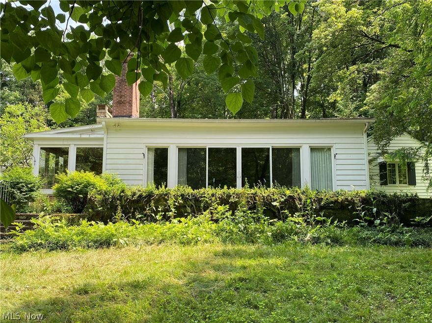 Attention investors or handy owners…wonderful opportunity to own this large 4-5 bedroom 3 full bath century home with great bones that sits on a 5 acre wooded lot with the Chagrin River crossing through it. Large detached garage has a wonderful knotty pine “party room” on second floor with complete with bar and fireplace.  Home was last renovated in 2001, so it is in need of updates but has great potential.  This home is being sold AS-IS.  The five acre lot is being split from its current 13 acres.  Buyer needs to agree to some deed restrictions designed to preserve the beautiful country setting (see supplement).  Adjacent land is part of the Western Reserve Land Preservation and nothing will ever be built on it.  Taxes reflect home on 13 acres and would be adjusted after lot split.  House cannot be sold with more land. Buyer must assume septic AS-IS.  Seller has no knowledge of current condition.  Sale is contingent on proposed lot split which needs to be surveyed and approved by coun