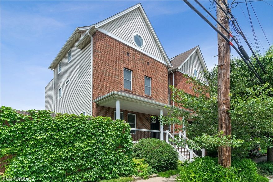 Welcome to 516 Literary Road! This Tremont home is just steps from dining and shopping, with beautiful views of Downtown Cleveland from the rooftop deck. Step inside from the wide front porch, noticing an open floor plan living, dining and kitchen area. Neutral paint, hardwood floors, recessed lighting throughout, and a cozy gas fireplace make this area perfect for entertaining! An expansive bar in the kitchen offers lots of counter space for preparing your favorite meals, or additional seating for guests. Granite countertops adorn custom cabinets for extra storage, and stainless steel appliances remain with the home. A half bath completes the main level. Upstairs, discover a spacious master bedroom with ensuite, featuring a double vanity and an updated, rainfall walk-in shower. An additional bedroom and full bath complete this floor. The top floor offers a huge rec space with vaulted ceilings, closets for storage, wet bar and access to the rooftop deck, with potential to be an additio
