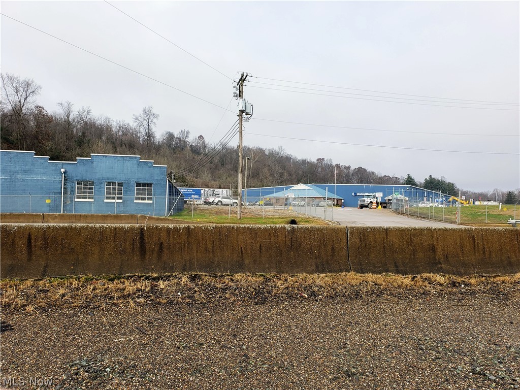 Property is 31 +/- acres total w/approx 18 acres wooded & rolling. Approx 13 acres are level w/improvements. The 60,000 = sq ft building built in 2005 includes 2 shop areas, offices of 100 & 560 sq ft plus expanded men's shop bath of 184 sq ft. A compressor room was added to the west side of 168 sq ft. A paint room w/built in vented steel equipment area and a computerized test stand. There is a 250' monorail w/a 2 ton crane+ another 2 ton crane mounted on a steel pivotal mast. The mechanics bay includes 5,168 sq ft area w/it's own outside mounted gas forced air system, fire resistant drywall & a dual I beam w/ a Konecrane 5 ton crane. Air compressor lines have been run through the shop. Attached is a 3000 sf brick sided office, finished into 9 rooms and large womens & mens baths. The 6319 sq ft block building was built in 1952w/ shed in 1996. Stone ramp loading area, some new doors, lights and other improvements have been made.
The area is enclosed w/ chainlink fence built in 2013. 10