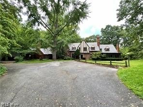 Step into luxury with this exceptional 1924 Tudor house boasting over 5400 square feet of living space. This grand home features five bedrooms, three full and two half bathrooms, offering ample space for comfortable living and entertaining. As you explore the home, you'll be greeted by a large parlor room/game room, a living room, and a family room - all three rooms exuding charm and warmth with charming fireplaces. These spaces provide the perfect setting for gatherings, relaxation, and entertainment. The main floor also includes an inviting eat-in kitchen, a main-floor laundry room, and multiple porches, including a four-season porch, a three-season porch, and a screened porch. The outdoor oasis features a fenced-off pool area with a pump house and storage for all pool equipment, creating a private retreat for outdoor enjoyment. The grand wood staircase leads to an upstairs office, library, and master suite with a reading area and direct access to the library. The remaining bedrooms share access to the other full bathrooms, offering comfort and convenience for family and guests. This home has elegance and practicality, with a three-car garage featuring a spiral staircase leading to a lower storage area. Take advantage of the opportunity to make this Tudor masterpiece your own. Schedule a showing today and experience this remarkable home's timeless beauty and luxury.