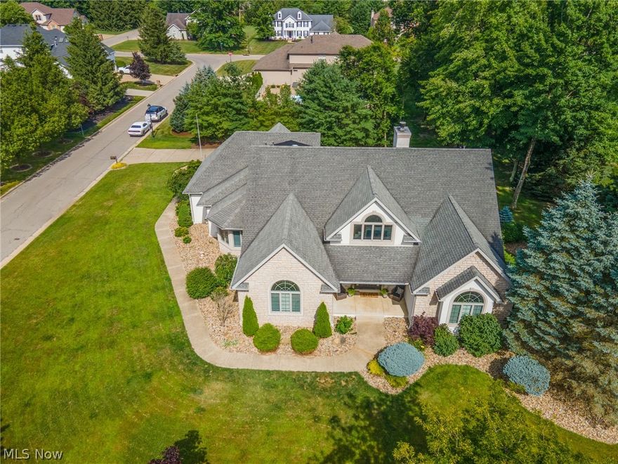Remarkable home situated on corner lot in The Cloisters. The main floor of this home boasts a 2 story foyer that looks into the cat walk and into the large great room with soaring ceilings, wall of windows and 2 story stone gas fireplace. Updated gourmet eat in kitchen with top of the line appliances, gorgeous cabinetry, and quartz counters with matching backsplash. Formal dining room with hardwood floors, 1st floor laundry, oversized office with separate entrance great for a home based business and the owner's suite with full bath and walk in closets. Bedrooms 2 & 3 share an updated full bathroom while 4th bedroom has en suite full bath and large walk in closet. Fun and airy loft great for the kids chill spot overlooking the great room and foyer complete the second floor. The finished lower level has a family room, possible 5th bedroom, full bath and exercise area. New landscape yard with stone beds, stamped concrete rear patio, partially fenced in rear yard with a 3 car garage and additional parking with oversized concrete driveway. All of this wrapped up and for sale in the highly sought after Canfield School District. Stop by and check this beauty out!
