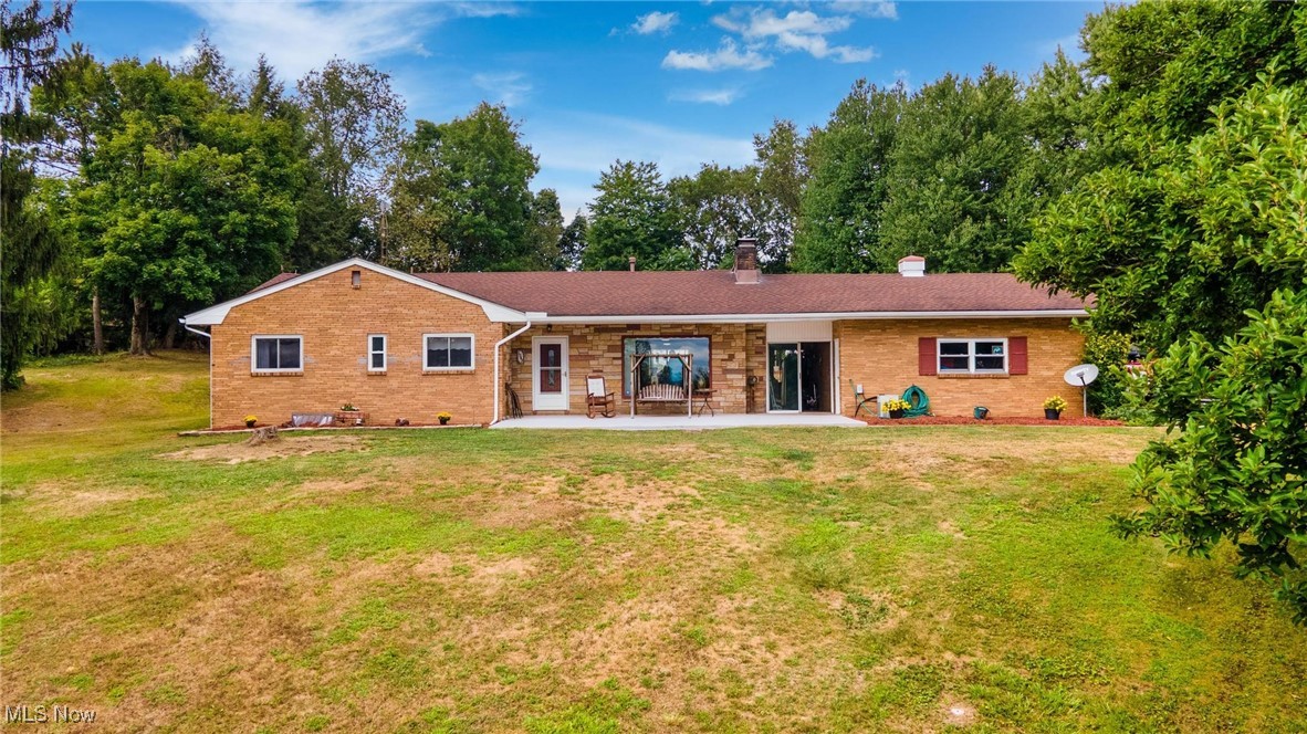 3/4 BEDROOM, EASY ENTRY HOME AWAITS ITS NEXT OWNER!! Over approx. 2500 sq. ft this brick ranch offers, also, an easy entry and a convenient breezeway leading to a welcoming living/dining room combo. Enjoy seamless indoor-outdoor living with 2 sets of sliding doors that lead to a covered patio, perfect for hosting gatherings year-round. This home is designed for entertaining, just off the updated kitchen, a den that can accommodate all your hosting needs with roasters or crockpots. The sunroom features a gorgeous slate floor that captures the morning light. The dining area has two amenities to offer-a pellet stove surrounded by a cozy mantle and a picturesque window to embrace stunning views of the Ohio & West Virginia landscape, especially after the leaves have fallen. Main floor updated bathroom boasts a jacuzzi tub to provide modern comforts, while the master bedroom boasts his and hers closets and a convenient half bath. A spiral staircase leads to a huge rec room with a wood-burning fireplace and a wet bar, perfect for continuing the party or relaxing in the game room. A bonus room feature of potential soundproofing (per previous owners) adds to the allure of this home. Plenty of storage space, a walk-out entrance to the patio, a saltwater above-ground pool with deck, and two additional outbuildings are just some of the added bonuses. The concrete driveway offers comfortable parking for 5-6 cars, with the unique option to park between the tree stumps. This property is located just shy of 2 acres and has an oversized one car garage. Located just approximately 2 miles from a major highway, this property offers the perfect balance of peaceful country living with convenient access to amenities. Don't miss the opportunity to make this exceptional home yours!