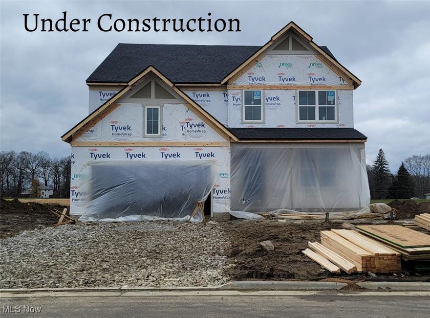 New construction by Drees Homes in the desirable Spring Hill Villas community in Green, Ohio. The Northwood plan offers 4 bedrooms, 2.5 baths, a Home Office, and a Dining/Flex Room. Corner lot with peaceful pond views. Light and bright exterior with cedar-wrapped wood columns and black garage doors for standout curb appeal. The Family Room features a gas fireplace with a full-height stone surround. The kitchen includes a gas range, arctic white backsplash, warm Quill cabinetry with matte black hardware, and Calacatta quartz countertops. The Primary Bath features a soaking tub, frameless glass shower, and designer mirrors. Luxury vinyl plank flooring throughout main areas, soft carpet in bedrooms and Game Room. Wainscoting in Foyer and Dining Room. Energy-efficient tankless gas water heater.