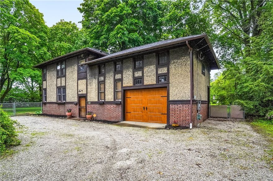 A One-of-a-Kind in the Heart of Akron. Discover this truly unique and special property—a meticulously restored 1910 carriage house set on a park-like parcel in the heart of Akron. Nestled on over an acre of beautifully landscaped grounds, this exceptional home blends historic character with modern comfort. Inside, the main level features an open-concept floor plan with exposed beam ceilings, rich wood-plank and interior brick walls, and large windows that flood the space with natural light and offer stunning views of the fully fenced, expansive yard. A cozy wood-burning stove adds warmth and charm. A wide, open staircase leads to the second floor where you'll find three spacious bedrooms, including a generously sized primary suite. An additional loft space provides flexibility for a fourth bedroom, office, or creative space. The main bathroom features an oversized whirlpool tub, while a second full bath is ready for finishing touches. A convenient second-floor laundry and a private balcony overlooking the lush backyard complete the upper level. Outdoors, the property feels like a secluded retreat, offering two patio spaces, a stone walkway, a newly added shed, storage beneath the balcony, and plenty of open lawn, mature trees, and shrubs that provide shade and privacy.  There have been many updates, including a renovated bathroom, newer roof, gutters and downspouts, a high-efficiency furnace and AC, new electric and plumbing, updated interior lighting, carpeting and glass block windows, and much more! A tankless water heater was installed in 2021.