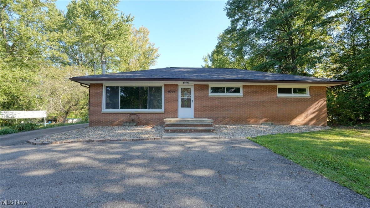 Welcome home to this charming brick ranch nestled in the desirable Green Local School District! Boasting three bedrooms and two bathrooms, this home is designed for comfort and convenience. The inviting eat-in kitchen provides a cozy space for meals, while the spacious living room features a stunning Buck Wood Stove fireplace and a large picture window that floods the space with natural light. Large partially finished basement with a full bathroom. Step outside to the expansive deck, perfect for relaxing while overlooking 0.69 acres of breathtaking views. This property is packed with updates, including a new roof (May 2024), updated landscaping featuring a beautiful small pond (Summer 2024), and a freshly built deck (August 2023). A well pump and bladder tank were replaced in September 2022, accompanied by a chem-free water treatment system installed in January 2023 for added peace of mind. The fireplace has been replaced with a Buck Woodstove (November 2024), offering both warmth and rustic charm. A turnaround driveway added in July 2022 enhances accessibility, while Drylok basement sealing (April 2025) and updated house gutters (2023) ensure lasting durability. Outside, the clean garage includes a convenient attached work shed as well as a potting shed for additional storage or gardening tools. Inside, the basement, first-floor bathrooms, and first-floor laundry have been recently remodeled, making this home move-in ready. Don't miss out on this gem—schedule your showing today!