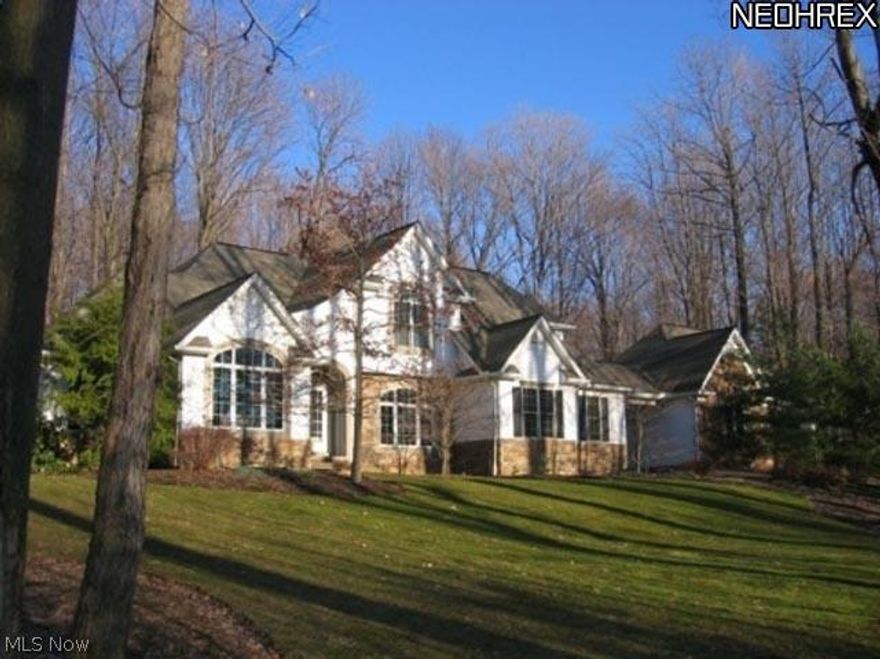 This Payne and Payne custom built house is located in the beautiful Boulder Creek Subdivision of Munson Twp. It is situated near the end of a cul-de-sac, on a partially wooded 5 acre lot with over 300 ft. frontage. This nature lover's retreat also includes a large barn with a cedar porch and deck. Inside the house you will find spacious rooms, vaulted ceilings, cherry hardwood floors, solid surface counters, cherry Kraftmaid cabinets, a wood burning fireplace and a gas stove in the family room. The master suite is on the 1st floor and three additional bedrooms and two full baths are on the 2nd floor. The Library has french doors, and full wall cherry bookshelves. The lower level rec room has solid oak walls, carpeting and an entertainment center with a gas fireplace.