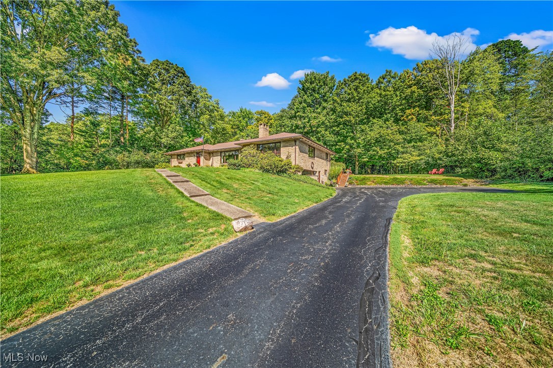 Sprawling ALL BRICK Ranch Style Home In Russell With Chagrin Falls Mailing Address On 1.5 Acres * Over 2740 Square Feet * Walk Out Lower Level * Inviting Kitchen With Granite Countertops And Breakfast Room Offering All Appliances * Gorgeous Hardwood Flooring Throughout Most Of The Home * Massive Family Room With Built In Shelving And Sandstone Wood Burning Fireplace Which Is See-Through To The Living Room * Bright, Light, Living Room With Large Window, Open Concept To Spacious Dining Room With Hutch That Opens To Full Staircase Up To Large Attic * Owners Suite Has Private Full Bath * First Floor Laundry Room With Plenty Of Cabinetry And Also Back Door To Trex Decking * Backyard Is Breathtaking With Private/Wooded Views * Lower Level Is Walk Out And Recreation Room Has Wet Bar, Office/Den, And Storage Area * Prime Location And Comfortable Home * Roof And Gutters Approximately 9 Years Old * Hot Water Tank 3 Years Old * West Geauga Schools * Call For A Private Showing Today!