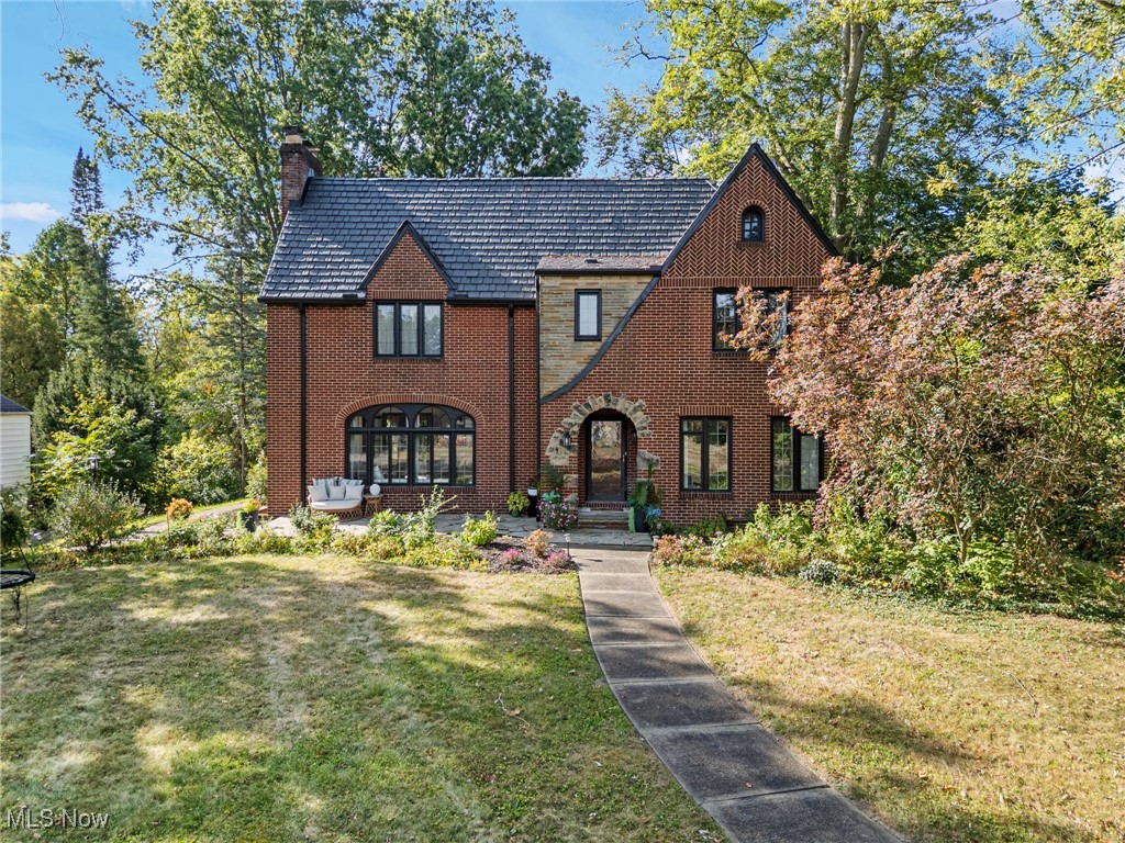 Discover the perfect blend of historic charm, modern updates, and unmatched versatility in this stunning all-brick Tudor, set on 1.12 acres of private land with secluded views of the Alliance Country Club golf course. Built in 1929, this architectural masterpiece offers rare character and space. The main residence features 4 bedrooms and 2.5 baths, showcasing exquisite craftsmanship throughout—from rich original woodwork to arched Palladian windows and decorative stone accents. A striking new steep-pitched roof (2023–2024) with a 75-year synthetic slate warranty crowns the home—part of a $228K roof and gutter investment. Inside, a grand foyer leads to a spacious living room with a full-wall wood-burning fireplace. French doors open to a sun-drenched library, perfect for reading or quiet reflection. The chef’s kitchen boasts abundant counter space, a warm wooden ceiling, crown molding, and an expansive eat-in area that flows into the formal dining room with charming built-ins. Upstairs, hardwood floors continue through the luxurious primary suite with its own fireplace, dual closets, and private bath, along with three additional bedrooms and a beautifully renovated hall bath. The third floor is a partially finished attic with high ceilings and lots of space, offering potential for even more living space. Adding incredible value to the property is a separate 2-bedroom guest house with its own kitchen, bath, laundry, and living area. Whether used as a private in-law suite, a space for extended family, or as a rental property for extra income, this cabin expands the possibilities well beyond the main home. Outside, enjoy the oversized 19’ x 23’ deck for entertaining or simply soaking in the peaceful backyard views. The property also includes a full basement with generous storage, a 2-car attached garage, and a covered 2-car carport. All this in a prime location, just minutes from Silver Park, Mount Union, and local shops.
