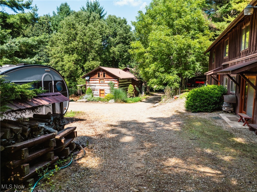 Parcel 1 includes 15.007 acres and offers a collection of unique and functional structures. The main home is a well-crafted log cabin featuring hardwood floors, a main-floor bedroom and bath, a spacious kitchen and dining area, and additional bedrooms upstairs. A wood-burning fireplace serves as the primary heat source, with backup propane and central air conditioning. The cabin also includes a whole-house Generac generator, a deck area, and a covered sauna with a nearby shower. The land includes several small ponds and a large, stocked pond, adding to the property's scenic and recreational appeal.
Also located on Parcel 1 is a retreat building with multiple small bedrooms, bathrooms, common living areas, and kitchen facilities on both floors. It is heated with propane and cooled with window A/C units. An attached workshop with a wood stove and firewood storage extends its usefulness for a variety of purposes.
In addition, there is a second home on the parcel that features a bedroom and kitchenette combo, a full bath, and a loft area, providing even more space for guests, extended family, or flexible use.