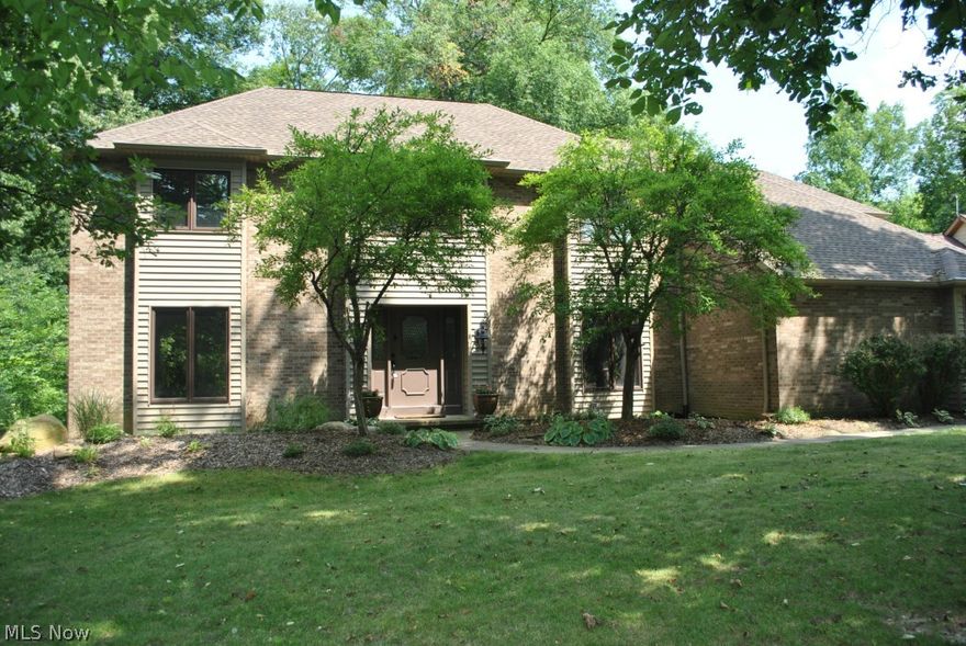 Attention to detail is what distinguishes this home from the competition.  Ornate 6" trim work and crown molding, Brazilian walnut hardwood floors and a gorgeous two story foyer with winding staircase greet you.  The layout is perfect for family life and for entertaining guests.  The family room features a wet bar and cozy fireplace, with views of the beautiful wooded lot behind the home.  The kitchen is open and spacious with a center island and separate dining area.  The formal dining room is large enough to comfortably accommodate large gatherings.  The basement features a rec room/theater space as well that just needs your finishing touches.  Entertaining continues outdoors with a large multi-level deck, gazebo, lighting and nature's splendor.  Other features include a first floor guest bedroom and first floor laundry.  Recent updates include flooring, trim work, roof (tear off), siding, gutters, water heater and more. Don't miss the 5th bed/3rd bath (teen or in-law suite) addition