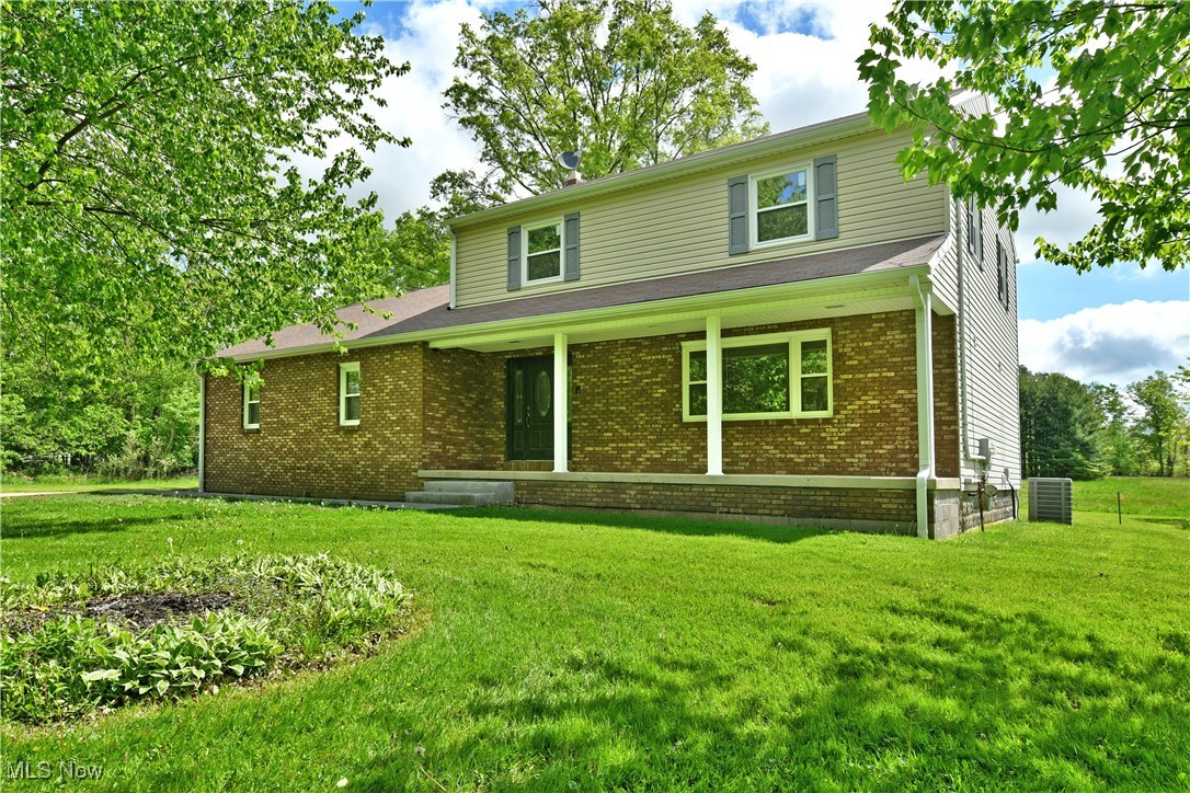 Warm and inviting from the inside out, this gorgeous Howland home will steal your heart and your attention as you immerse yourself within its must-see, move-in-ready living space! Tucked behind a row of tall trees, the natural privacy veils the handsome brick work that waits to be uncovered as the extended front patio offers a relaxing stay out of the sun. Meanwhile, a concrete driveway winds around to find the attached two car garage as the sidewalk continues around to the elevated rear deck where you can take in the scenic backyard views. Through the front door, a stained wood staircase rises from the closet lined foyer, setting the tone as hardwood styled flooring flows underfoot. Passing through the threshold, a spacious living room basks in the natural light provided by its oversized picture window. Formal dining is just around the corner with its own, decorative lighting choices. The short front hall takes you past a darling half bath as it opens into the combined central kitchen and casual dining space, set before sliding glass doors. Polished stone countertops accent the custom wood cabinetry and stainless appliances to create a rich feel. Steeping down, the large family room completes the floor with its prominent brick mantle and inset fireplace. Upstairs, four bedrooms line the hallway as a masterfully updated full bath joins them, showcasing its outstanding tile work. The impressive master suite seals the deal with its own, like-style full private bath. Laundry and storage are found at the basement level.