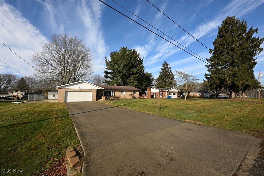 This is a home that everyone will find a reason to love! To begin, she's a brick ranch on a quiet street in New Franklin, just a stone's throw from Turkeyfoot Lake and Dano's Lakeside Pub. Situated on a half-acre flat lot with additional parking or RV pad on the home's south end, new chain link fencing around the back yard, a large metal shed out back, and an entertainer's patio with a grill/smoker, built-in pillar lighting, and a gas fireplace at the rear of the home. Inside this completely updated labor of love, there is so much to see, the refinished hardwood floors in the living, dining, hall, and north end bedrooms. New vinyl flooring throughout the remaining rooms, 2 wonderfully updated bathrooms (paint, backsplash, vanities, etc), and one completely remodeled master bathroom complete with his and her vanity, walk-in shower, soaking tub, tasteful flooring, well-appointed fixtures, and a combo exhaust fan, LED light, and Bluetooth capable speaker. Did I mention that each of the 3 bedrooms has ample closet space, a ceiling fan, and a wall-mounted flat-screen TV that will remain with the home? The same goes for the 65" smart TV and smart electric fireplace in the living room! The kitchen is a reflection of how much the previous owner put his heart and soul into this home, with newly painted cabinetry, beautiful wood block countertops, new backsplash, a farmhouse fireclay double-basin sink, a new center island with seating for four. The single south end bedroom is situated just off the kitchen and includes a half bath and walks out to the side driveway. It could easily double as an office or family room. The attached garage and basement stairwell open to the kitchen for maximum convenience. Finally, the basement has been completely remodeled with a Night At The Movies theme. Everything in the basement recreation room stays: antique barber chairs, audio and visual equipment, popcorn maker & mini fridge, plus all movie-related decor. Bonus bed/craft room, no egress