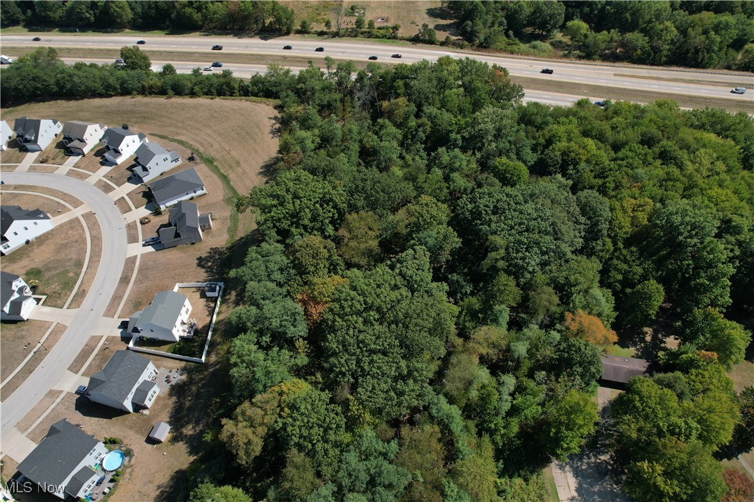 Beautiful 1.52-acre wooded lot in Tallmadge, ready for your future home! This parcel is accessed through Woodridge Place but is not subject to HOA deed restrictions. While the lot is landlocked, a 30' access and utility easement has been granted for the benefit of the property, and the parcel has been issued a Woodside Lane address.
The property is wide enough to accommodate an expansive ranch home, and there’s plenty of room to add an outbuilding or your dream garage. With minimal traffic through the community, you can enjoy a quiet setting set back from the street. Utilities are available at the street; buyer to verify all details and connection costs. Bring your preferred builder, or we can provide a recommendation.
Fantastic location with easy access to shopping, dining, highways, and situated within the Tallmadge School District.