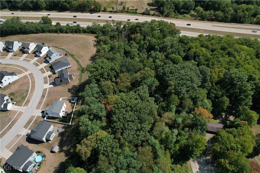Beautiful 1.52-acre wooded lot in Tallmadge, ready for your future home! This parcel is accessed through Woodridge Place but is not subject to HOA deed restrictions. While the lot is landlocked, a 30' access and utility easement has been granted for the benefit of the property, and the parcel has been issued a Woodside Lane address.

The property is wide enough to accommodate an expansive ranch home, and there’s plenty of room to add an outbuilding or your dream garage. With minimal traffic through the community, you can enjoy a quiet setting set back from the street. Utilities are available at the street; buyer to verify all details and connection costs. Bring your preferred builder, or we can provide a recommendation.

Fantastic location with easy access to shopping, dining, highways, and situated within the Tallmadge School District.