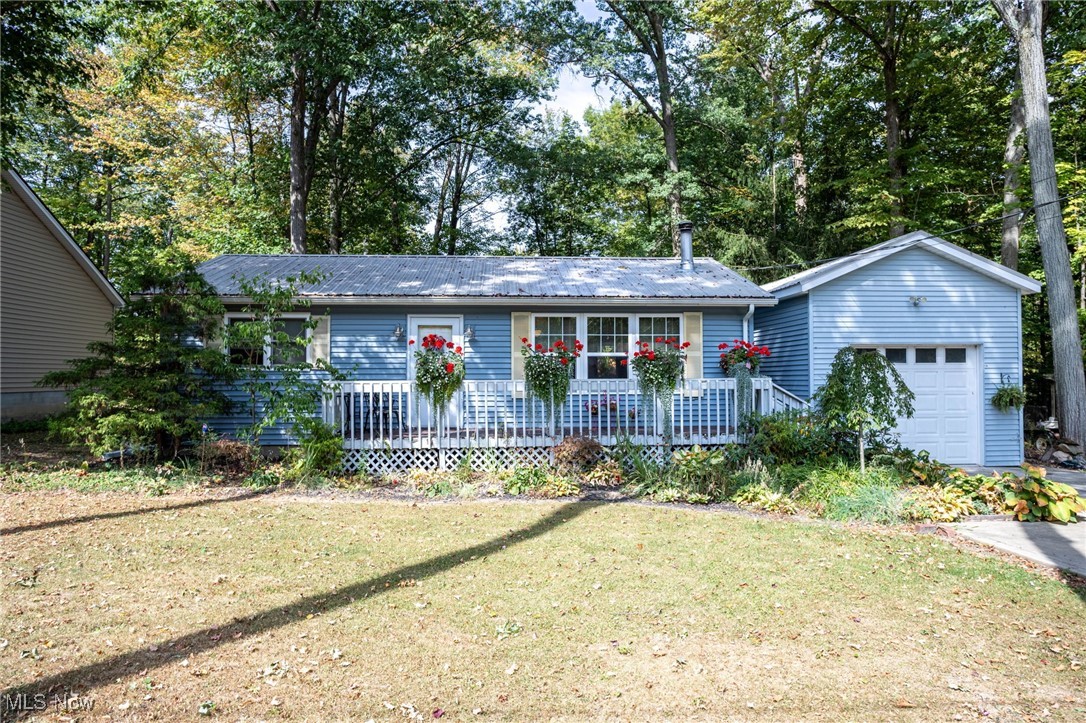 Tucked away on a quiet, wooded street, this charming 2-bedroom, 1-bath cottage ranch feels like a storybook retreat. A welcoming front deck sets the tone, leading you into a cozy family room where a wood-burning stove promises warmth on chilly evenings and new flooring adds a fresh touch underfoot. The eat-in kitchen blends rustic character with modern convenience, offering newer cabinets, a handsome backsplash, granite counters, and a deep farmhouse-style sink. A laundry area is thoughtfully tucked in, keeping everything close at hand. Both bedrooms are comfortably sized with plenty of storage, while the updated full bath offers a touch of charm with new tile, flooring, and vanity. Throughout the home, you’ll find handcrafted Amish woodwork, with accents of 120-year-old barn wood framing doorways, highlighting the kitchen, and adding timeless character in every corner. Out back, a spacious deck is the perfect place to unwind while listening to the woods and enjoying the peace of the quiet backyard. A handy shed provides storage, and the newer two-story garage holds a wonderful surprise—upstairs, a finished retreat space with its own heat and TV hookup makes the perfect hideaway for hobbies, games, or simply relaxing. All this, just a minute from the clubhouse, marina, pool, tennis, and more, giving you the feel of a private woodland escape with the perks of a vibrant community. If you’ve been searching for a cozy cabin-like getaway with modern comforts and resort-style amenities, this one is waiting for you.