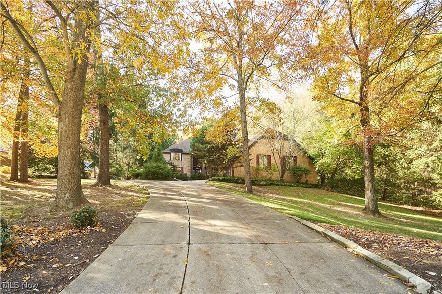 Private Retreat with First Floor Primary in Bath Township.  Enjoy privacy, nature, and timeless craftsmanship in this elegant Schleider-built Tudor nestled within The Sanctuary—one of Bath Township’s most desirable neighborhoods.  The home’s unique and stylish layout features a first-floor Primary Suite with two walk-in closets and an oversized bath. The two-story sunken Great Room impresses with a fireplace, wet bar, and stunning views of the wooded lot beyond. A sunroom tucked at the back of the home offers the perfect nature haven for morning coffee or quiet reflection.  The main level also includes a welcoming foyer with curved staircase, formal Living and Dining Rooms, a cozy paneled Den, and a versatile Office or Sitting Room, generous laundry with window and storage, and two (2!) half baths.. The spacious eat-in Kitchen boasts a center island, walk-in pantry, generous dining area, and access to a grilling deck. Upstairs, discover three additional bedrooms, including one large enough to serve as a second Primary Suite. All bedrooms feature walk-in closets, with an additional walk-in storage closet on the landing. The finished lower level offers a Rec Room, guest room, and half bath, plus two expansive unfinished areas perfect for storage, workshop, fitness space—the possibilities are endless. A three-car garage with extra storage pad and an alcove provides ample space for vehicles and outdoor equipment. Newer AC. The wooded lot, bordered in part by a meandering creek, adds a serene, natural backdrop.  Residents of The Sanctuary enjoy public water and sewer, varied architecture, proximity to shopping, dining, highways, parks, and more, and of course, the top-rated Revere School District.  Call today for your private showing and see how you can make this wonderful property your own!
