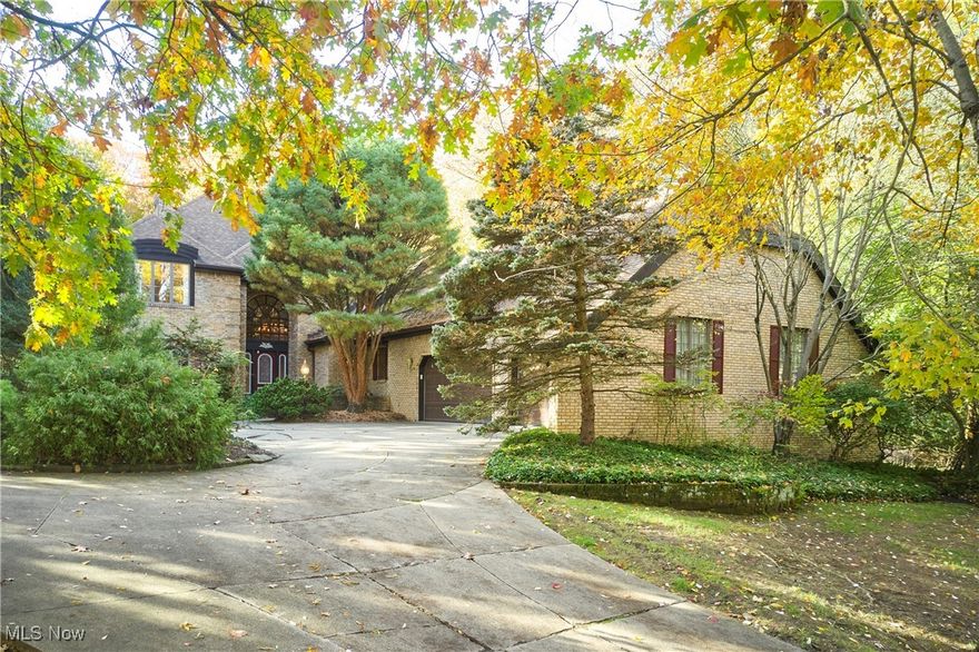 Private Retreat with First Floor Primary in Bath Township.  Enjoy privacy, nature, and timeless craftsmanship in this elegant Schleider-built Tudor nestled within The Sanctuary—one of Bath Township’s most desirable neighborhoods.  The home’s unique and stylish layout features a first-floor Primary Suite with two walk-in closets and an oversized bath. The two-story sunken Great Room impresses with a fireplace, wet bar, and stunning views of the wooded lot beyond. A sunroom tucked at the back of the home offers the perfect nature haven for morning coffee or quiet reflection.  The main level also includes a welcoming foyer with curved staircase, formal Living and Dining Rooms, a cozy paneled Den, and a versatile Office or Sitting Room, generous laundry with window and storage, and two (2!) half baths.. The spacious eat-in Kitchen boasts a center island, walk-in pantry, generous dining area, and access to a grilling deck. Upstairs, discover three additional bedrooms, including one large enough to serve as a second Primary Suite. All bedrooms feature walk-in closets, with an additional walk-in storage closet on the landing. The finished lower level offers a Rec Room, guest room, and half bath, plus two expansive unfinished areas perfect for storage, workshop, fitness space—the possibilities are endless. A three-car garage with extra storage pad and an alcove provides ample space for vehicles and outdoor equipment. Newer AC. The wooded lot, bordered in part by a meandering creek, adds a serene, natural backdrop.  Residents of The Sanctuary enjoy public water and sewer, varied architecture, proximity to shopping, dining, highways, parks, and more, and of course, the top-rated Revere School District.  Call today for your private showing and see how you can make this wonderful property your own!